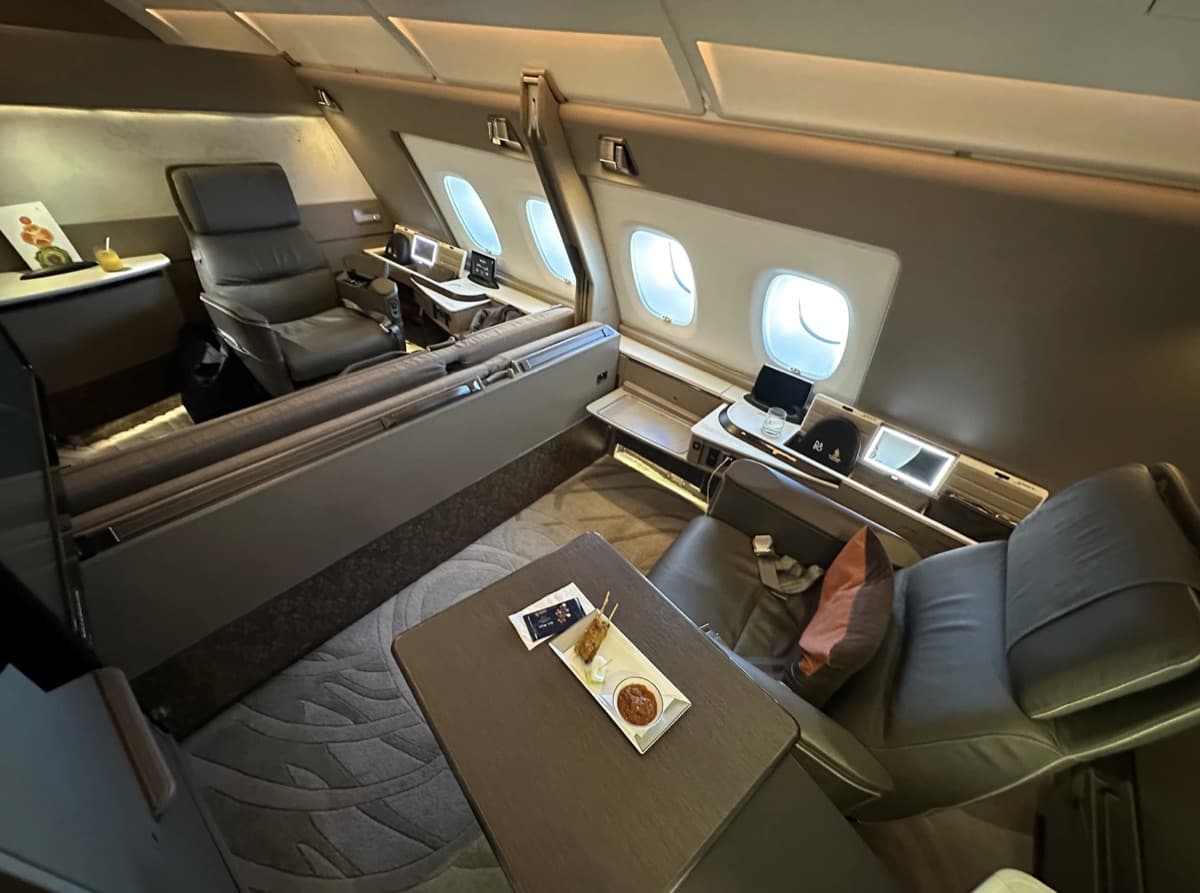 Singapore Airlines A380 Suites — enclosed private compartment with leather seat, ottoman, and dining table